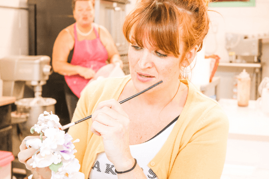 Woman decorating flowers for cake - the concept of creativity