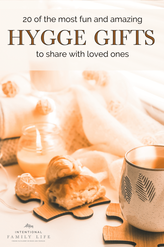 A warm candlelight image of hot chocolate and snacks with cozy blankets and home decorations suggesting hygge gifts; hygge gift ideas; and a hygge lifestyle
