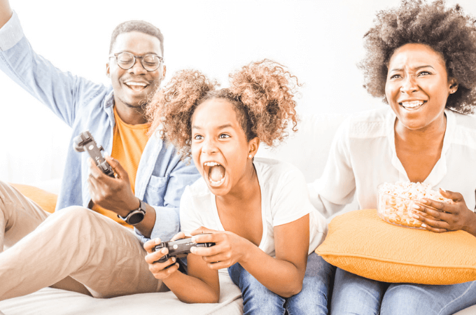 an image of a very happy and excited young woman with her parents on their sofa playing nintendo switch family games