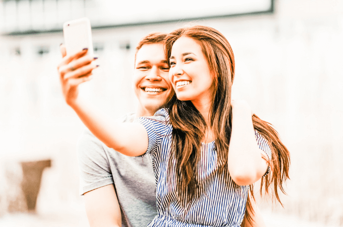 attractive young teenage couple happily taking selfie, suggesting healthy relationships